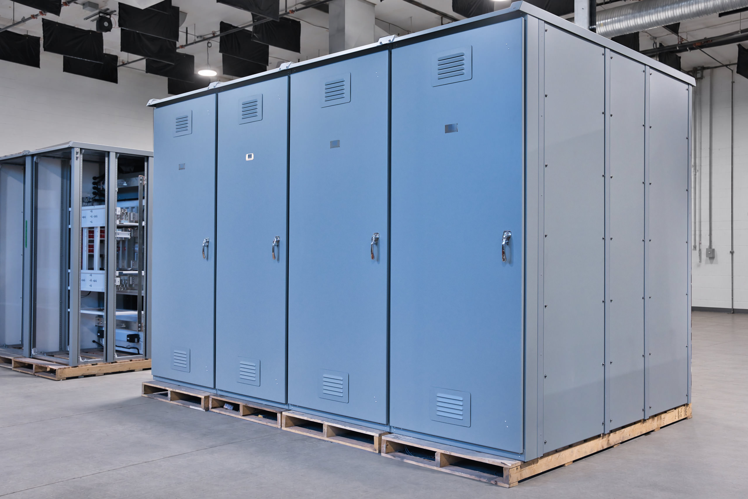 Outdoor-rated switchgear for hydroelectric power distribution, shown with its enclosure doors closed.