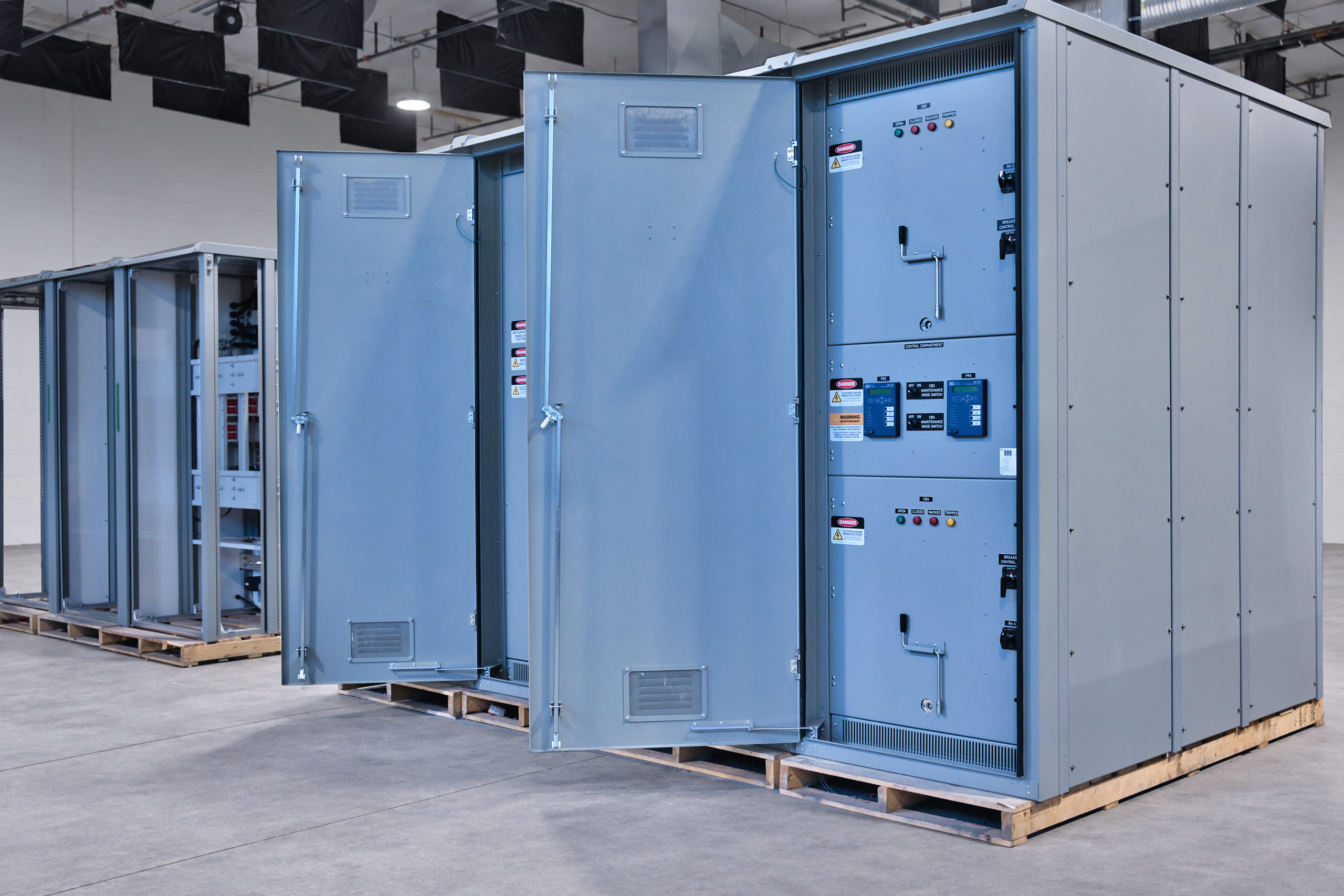 Hydroelectric switchgear with outer doors open, showing breaker controls and protection relays.